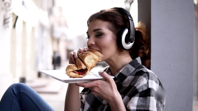 chica comiendo mientras escucha música con audífonos