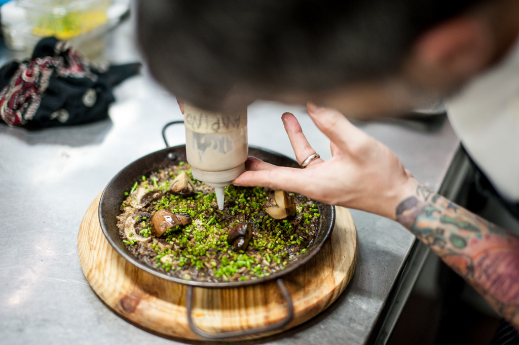 persona aplicando salsa a un plato